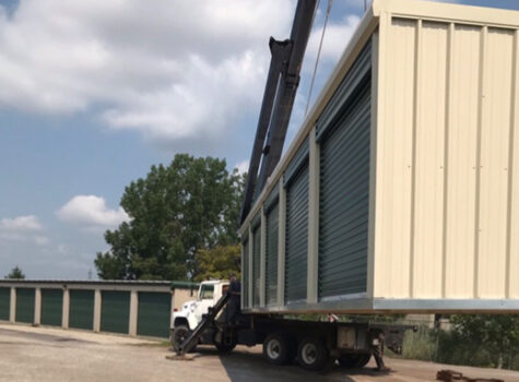 Transportation truck lifting storage unit with a crane