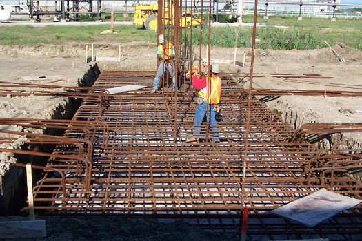 Workers setting rebar in place for pouring concrete foundations