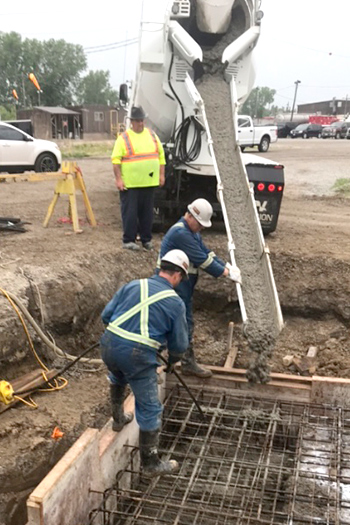 Workers pouring concrete from cement truck